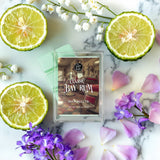 Wax melts packaging with sliced limes and flowers on a marble surface