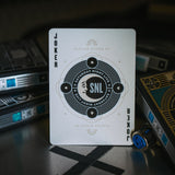 Playing card with 'SNL' logo on a dark surface