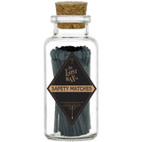 Glass jar with cork lid containing black safety matches labeled 'The Lost Wax Co.' on a white background.