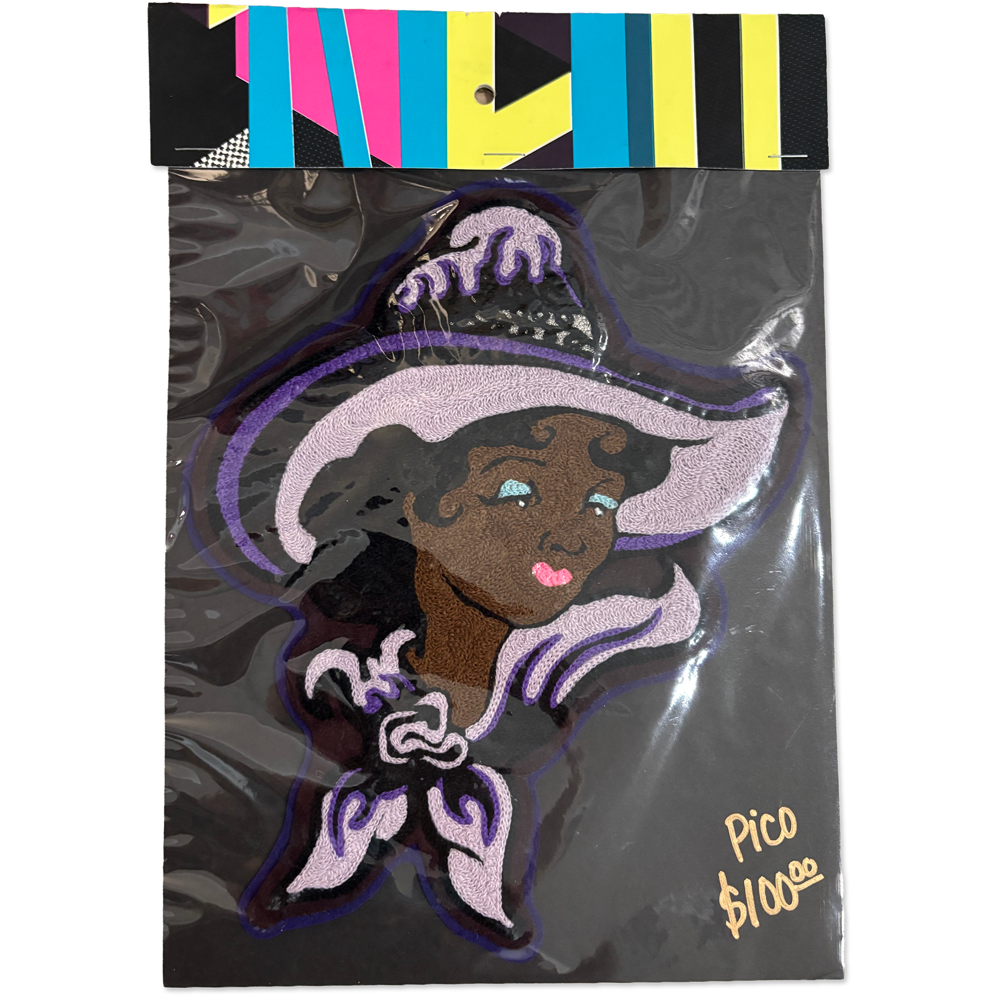 A packaged embroidered patch featuring a stylized witch character with a large lavender hat, dark hair, and purple trim, sealed in clear plastic with a colorful striped header card. Handwritten text in the corner reads 'Pico $100€'.