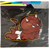A packaged handmade chainstitch patch featuring a cartoon devil baby on a black backing, with a colorful header card visible at the top.