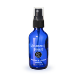 Blue spray bottle labeled 'Enchanted Forest' on a white background