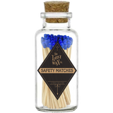 Glass jar with cork lid containing safety matches with blue tips and a visible brand label.