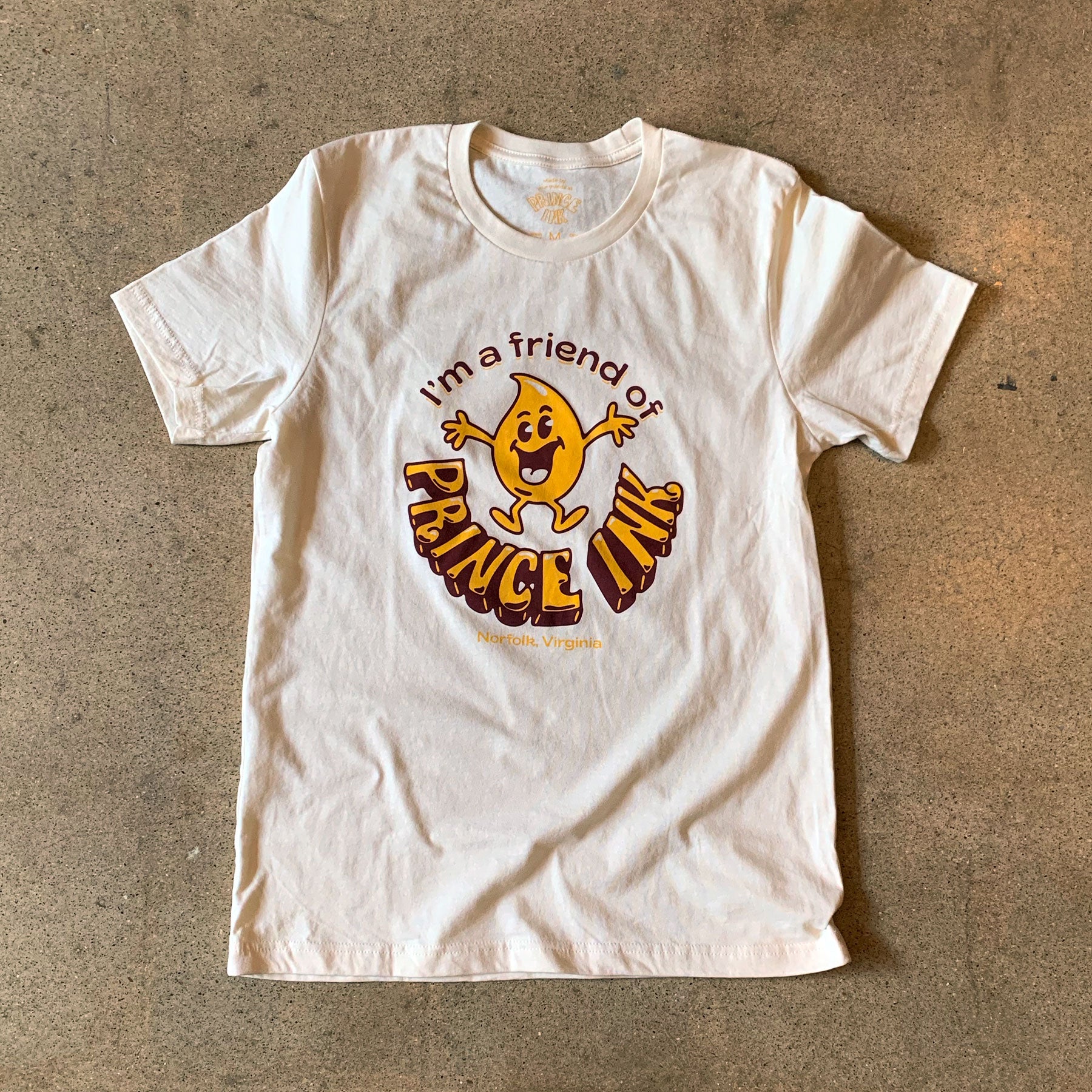 Cream T-shirt with retro-style graphic, "I'm a friend of Prince Ink Norfolk, Virginia" in yellow and brown.